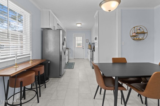 dining space with crown molding