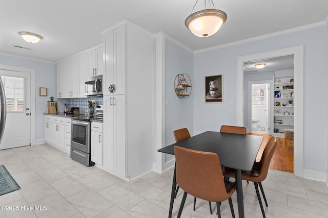 dining area with visible vents, crown molding, and a wealth of natural light