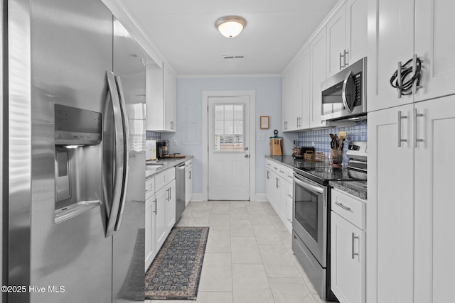 kitchen featuring backsplash, white cabinetry, stainless steel appliances, visible vents, and ornamental molding