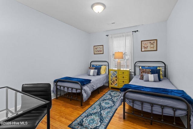 bedroom with visible vents and wood finished floors