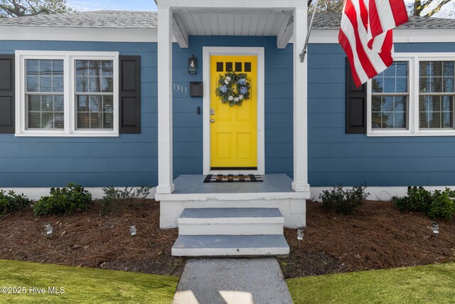 entrance to property featuring a shingled roof