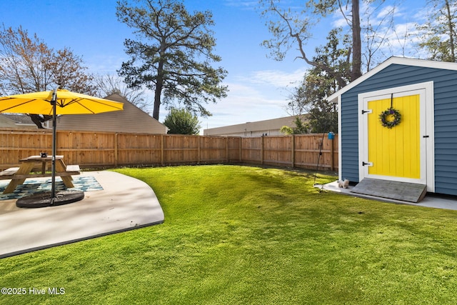 view of yard with a fenced backyard, an outbuilding, a patio area, and a storage shed