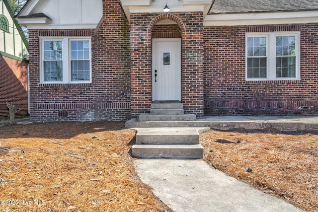 view of exterior entry featuring brick siding