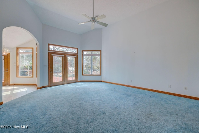 spare room featuring light carpet, a healthy amount of sunlight, baseboards, and ceiling fan