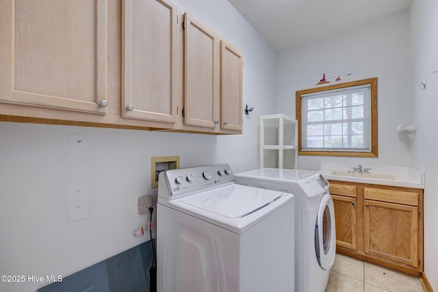 laundry area with light tile patterned floors, washing machine and dryer, cabinet space, and a sink