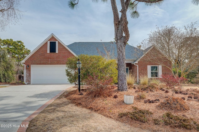 view of front of property featuring brick siding, driveway, and a garage