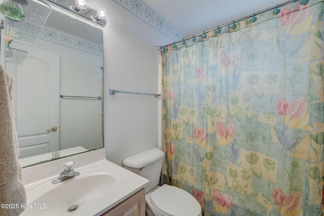 bathroom with toilet, vanity, and a shower with curtain