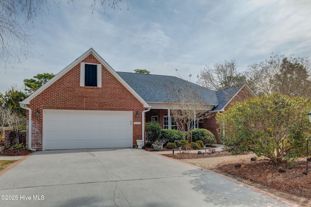 traditional home with brick siding, an attached garage, and driveway