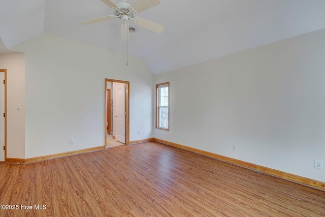 spare room with baseboards, light wood-type flooring, a ceiling fan, and vaulted ceiling