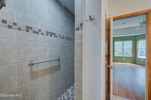 bathroom featuring tiled shower and ceiling fan