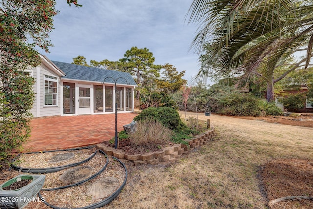 view of yard featuring a sunroom and a patio area