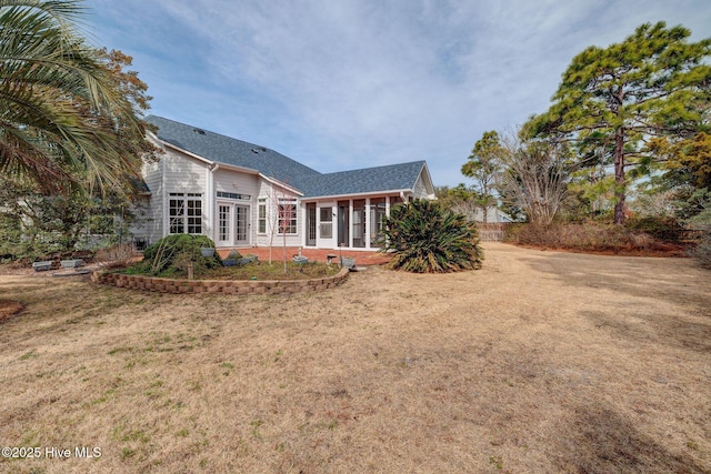 rear view of house featuring french doors, a shingled roof, and a yard