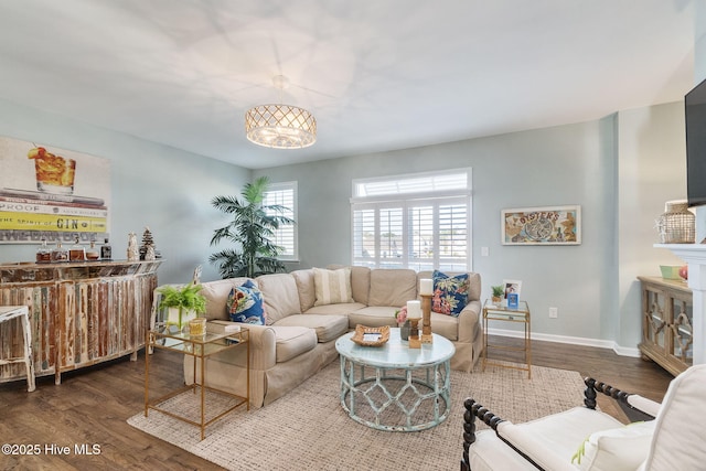 living area featuring bar, wood finished floors, and baseboards