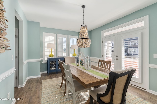 dining space with a notable chandelier, a healthy amount of sunlight, and wood finished floors