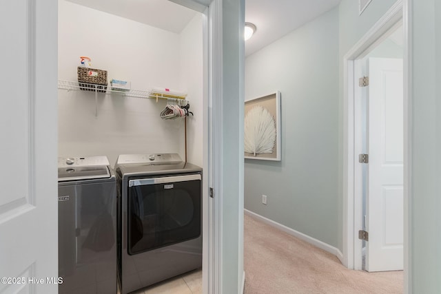 laundry room featuring laundry area, washing machine and dryer, baseboards, and light carpet