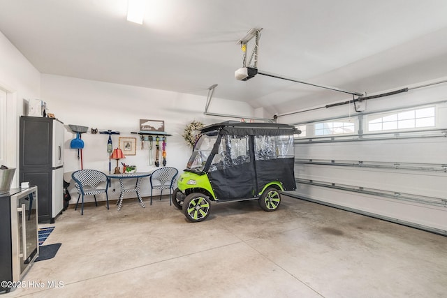 garage featuring wine cooler, a garage door opener, and freestanding refrigerator