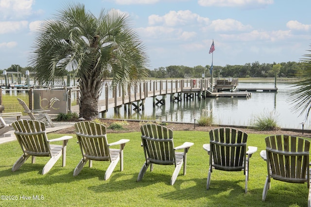 dock area with a lawn and a water view