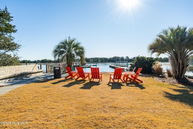 view of yard with boat lift, a water view, and a boat dock