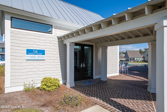 property entrance featuring french doors and a standing seam roof