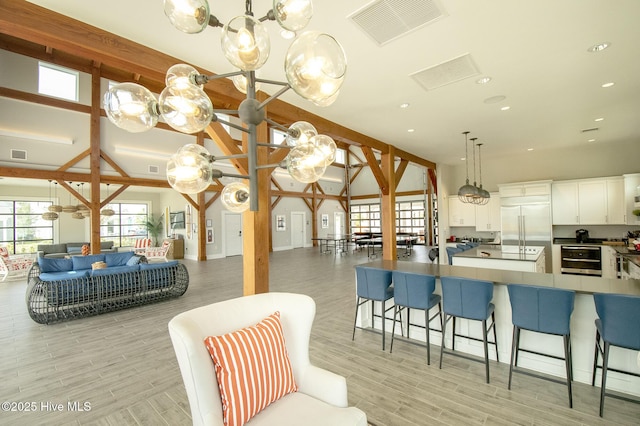 kitchen with a notable chandelier, visible vents, open floor plan, and built in fridge