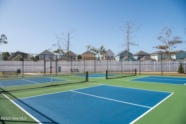 view of sport court with community basketball court, fence, and a residential view