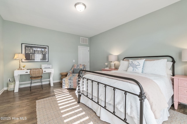 bedroom featuring wood finished floors, visible vents, and baseboards