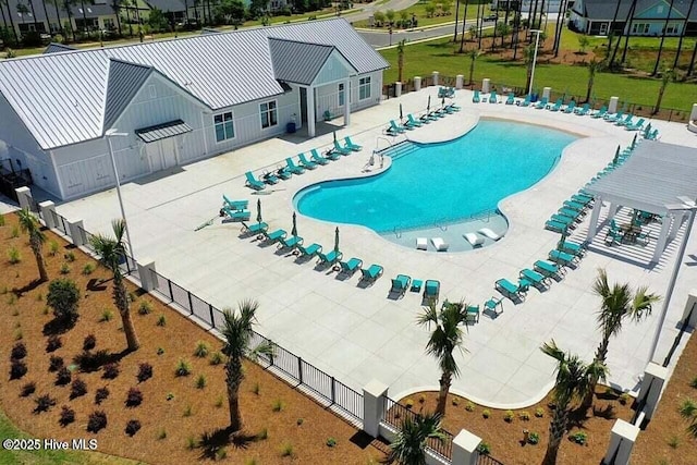 pool with a patio, fence, and a lawn