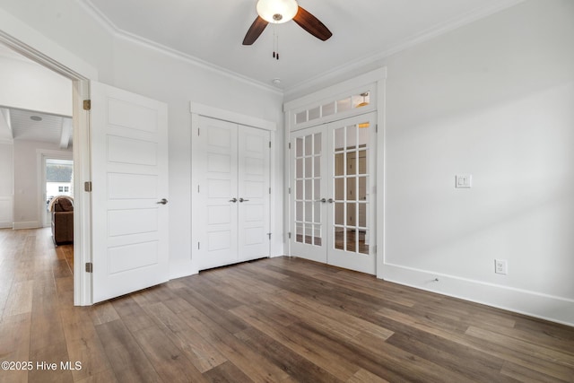 unfurnished bedroom with a closet, baseboards, french doors, crown molding, and wood finished floors