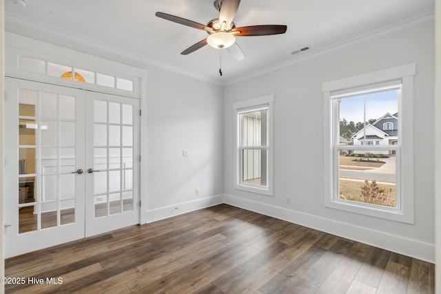 spare room with visible vents, ornamental molding, ceiling fan, wood finished floors, and french doors