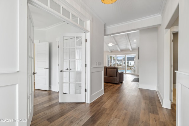corridor with crown molding, baseboards, beam ceiling, and hardwood / wood-style flooring