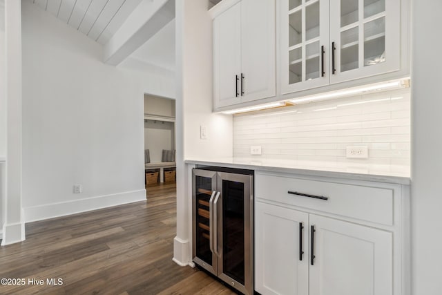 bar featuring wine cooler, backsplash, beamed ceiling, baseboards, and dark wood-style flooring