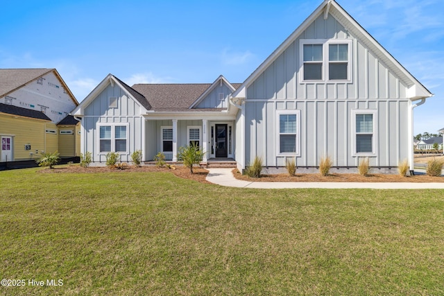 view of front facade featuring a front yard, board and batten siding, and a shingled roof