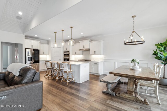 kitchen with open floor plan, a notable chandelier, white cabinetry, and appliances with stainless steel finishes