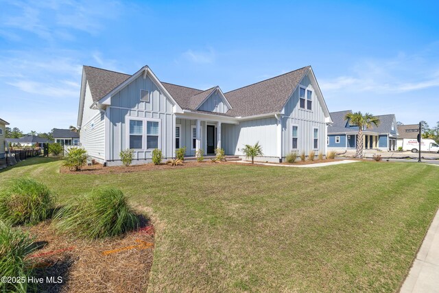 view of front facade featuring a front yard, board and batten siding, and a shingled roof