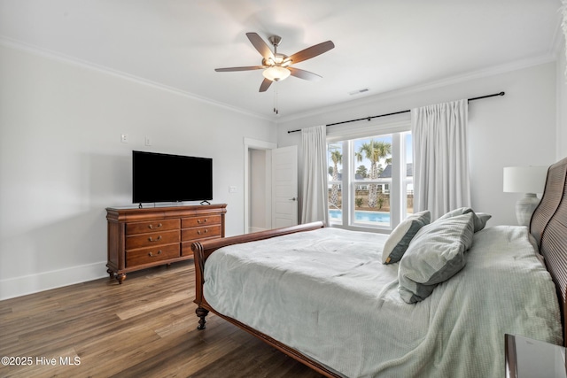 bedroom featuring wood finished floors, visible vents, crown molding, and baseboards