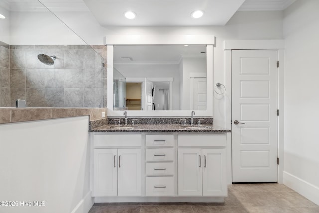 full bathroom with crown molding, double vanity, a sink, and walk in shower