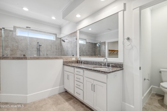 full bath with a walk in shower, a sink, toilet, and crown molding