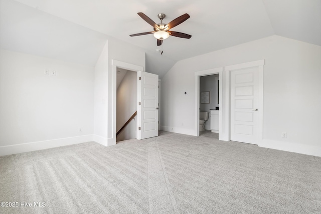 unfurnished bedroom featuring carpet flooring, baseboards, and vaulted ceiling