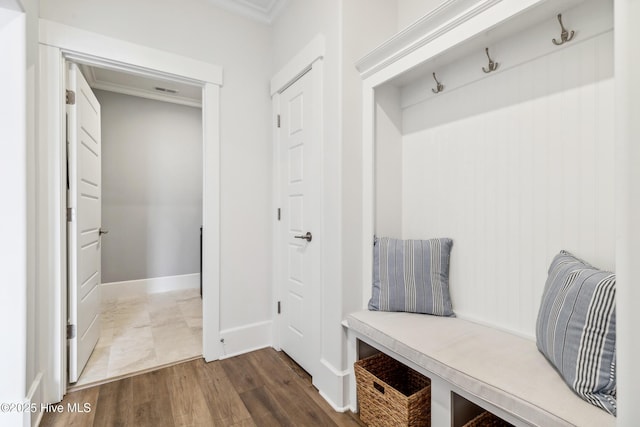 mudroom with dark wood-type flooring, baseboards, and ornamental molding