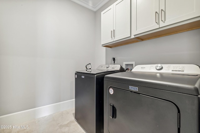 laundry room featuring ornamental molding, tile patterned flooring, washer and dryer, baseboards, and cabinet space