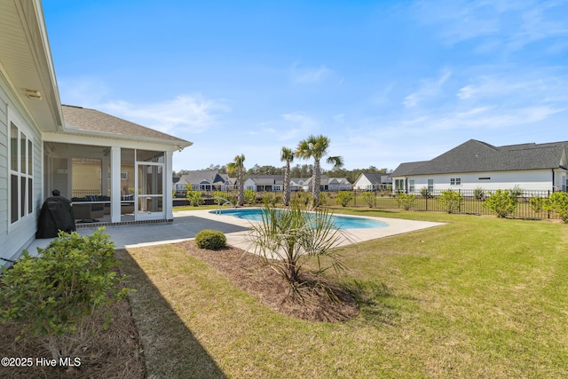 view of swimming pool with a residential view, fence, a sunroom, and a lawn