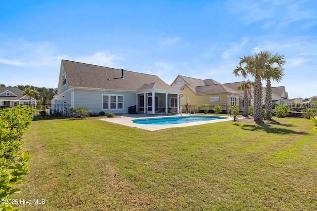 back of property featuring a fenced backyard, a fenced in pool, a sunroom, and a lawn