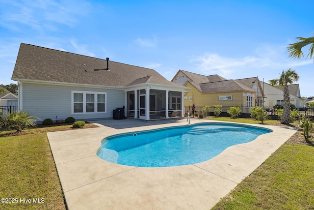 view of swimming pool featuring a fenced in pool, a patio area, a fenced backyard, a sunroom, and a lawn