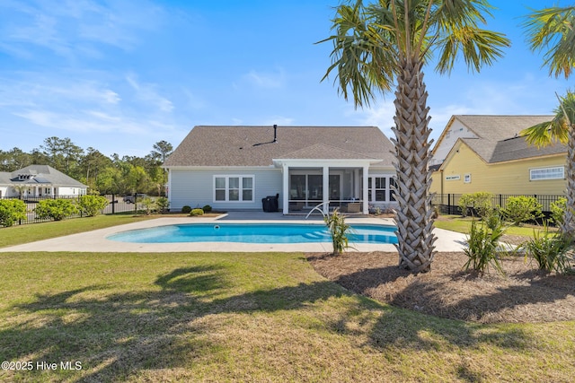 view of swimming pool with fence, a fenced in pool, a sunroom, and a lawn