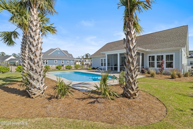view of swimming pool featuring fence, a patio, a yard, and a fenced in pool