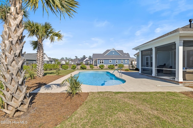 view of swimming pool with a lawn, a sunroom, a patio area, and a fenced in pool