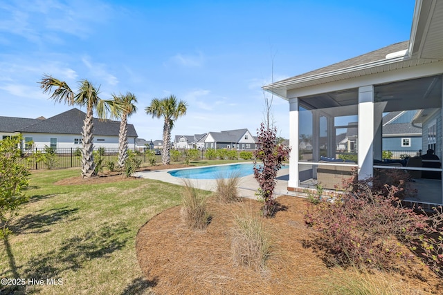 view of swimming pool with a fenced in pool, a residential view, a sunroom, a yard, and fence
