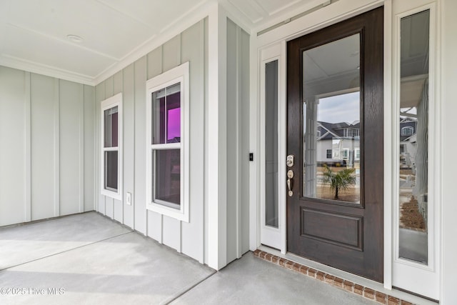 view of exterior entry with a porch and board and batten siding