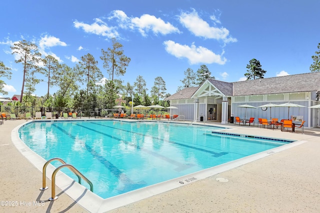 community pool with a patio area and fence