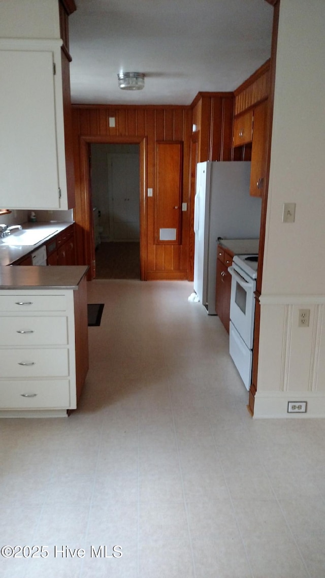 kitchen featuring white appliances, white cabinets, and a sink